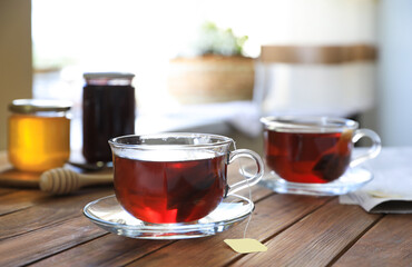 Tea bag in glass cup on wooden table indoors