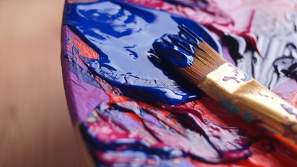 Artist's palette with mixed paints and brush, closeup