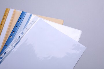 File folders with punched pockets and paper sheets on light grey background, above view - obrazy, fototapety, plakaty