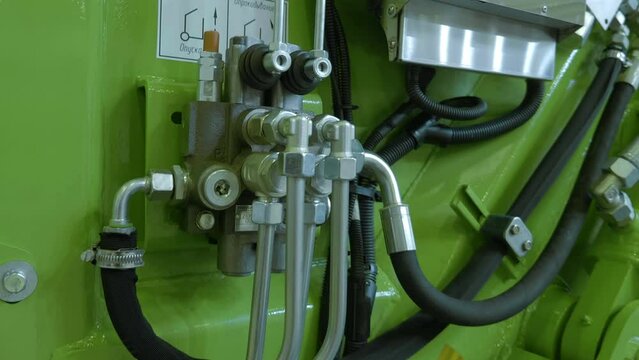 The block of hydraulic control valves of the new truck, which is responsible for the movement of the body, crane, winch, compaction of garbage. Shot in motion. Closeup