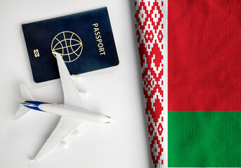 Flag of Belarus with passport and toy airplane. Flight travel concept 