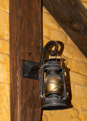 An old classic oil lantern burns with an orange flame.