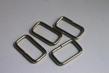 four metal rectangular rings on a white background