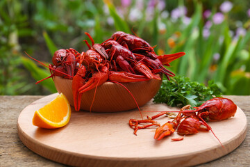 Delicious red boiled crayfish and orange on wooden table