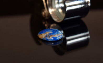 Opal is an opal pendant necklace placed on the ground.