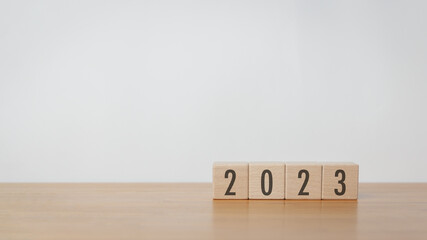 Wood cube block with 2023 text in white background. New year goal, action plan, business plan,...