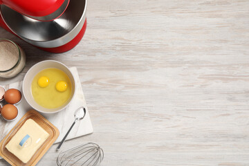 Modern red stand mixer and different ingredients on white wooden table, flat lay. Space for text