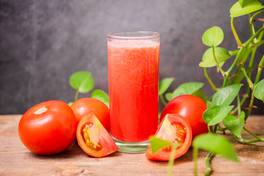 Fresh tomato juice on wooden table