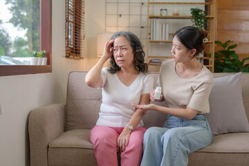 Asian caregiver or daughter take care of the elderly at home in the living room, providing timely...