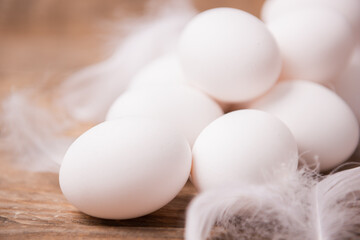 Fototapeta na wymiar Fresh white eggs and feathers