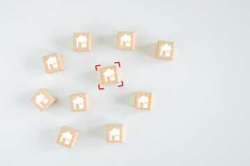 Real estate, Property investment and asset management concept. Red focus house icon on wood cube from many house. Decision to choose the best property with your right. Choosing suitable housing.