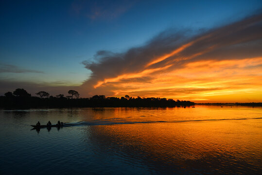 A small motorized canoe during sunset on the Guaporé - Itenez river, Ricardo Franco village, Vale do Guaporé Indigenous Land, Rondonia, Brazil, on the border with Bolivia