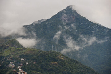 The cloud-shrouded Pico do Andaraí Maior peak above the dense Atlantic rainforest of the Tijuca...