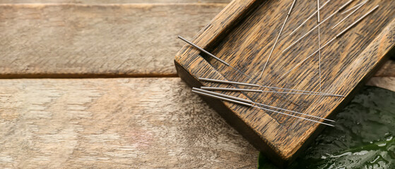 Board with acupuncture needles on wooden background with space for text, top view - obrazy, fototapety, plakaty
