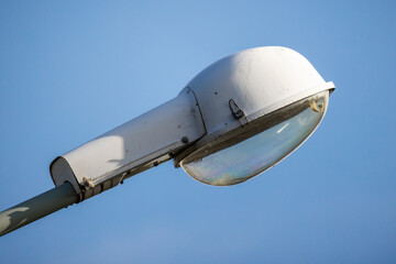 Fototapeta na wymiar Urban street lamp is under blue sky on a daytime, close up