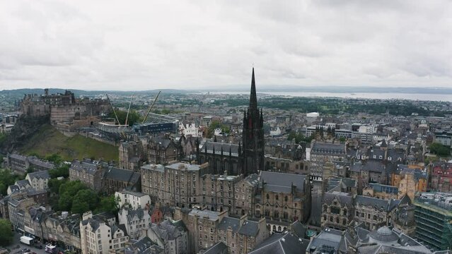 The Hub tower and Edinburgh Castle on hill in the morning. Aerial orbit cityscape of old town.