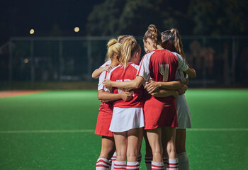 Huddle, soccer teamwork or football women on soccer field or stadium at night for support,...