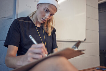 Woman, sport coach and clipboard writing of an athlete writing exercise schedule or plan. Personal...