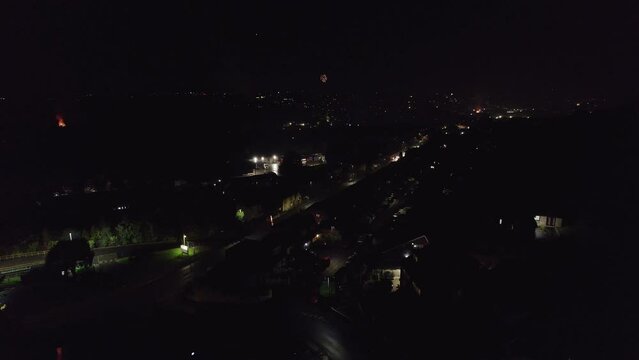 Typical November the 5th Bonfire night in the United Kingdom. Dark cold and wet, showing street lights cars houses and fireworks. Drone footage