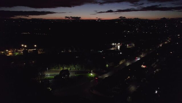Drone video of English November the 5th Bonfire night in the United Kingdom. Dark cold and wet, showing street lights cars houses and fireworks. Drone footage