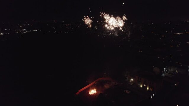 Drone, English November the 5th Bonfire night in the United Kingdom. Dark cold and smoky, showing street lights cars houses and fireworks. Drone footage