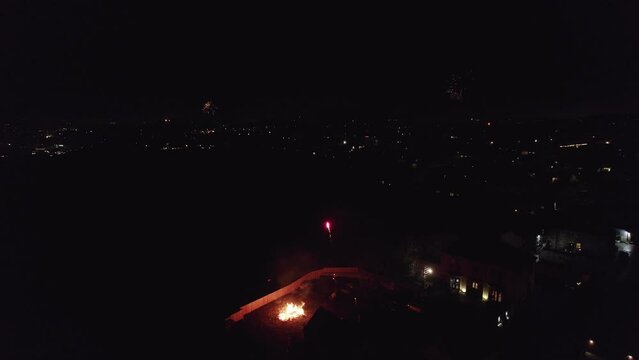 Drone, English November the 5th Bonfire night in the United Kingdom. Dark cold and wet, showing fires, street lights cars houses and fireworks. Drone footage