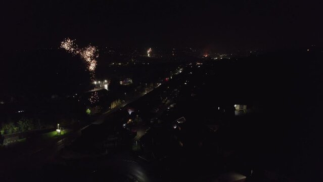 Typical English November the 5th Bonfire night in the United Kingdom. Dark cold and wet, showing street lights cars houses and fireworks. Drone footage