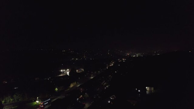 Very typical November the 5th Bonfire night in the United Kingdom. Dark cold and wet, showing street lights cars houses and fireworks. Drone footage