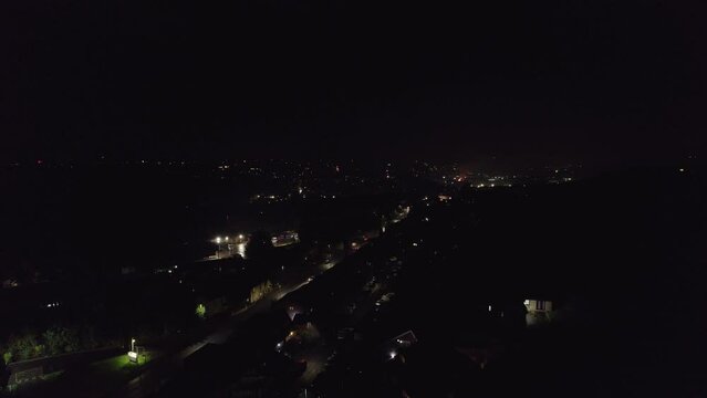 Drone, English November the 5th Bonfire night in the United Kingdom. Dark cold and wet, showing street lights cars houses and fireworks. Drone footage