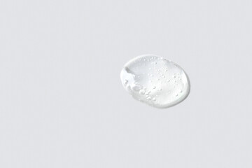 Ttransparent cosmetic smear sample with bubbles texture on light grey background. Skin care y body treatment
