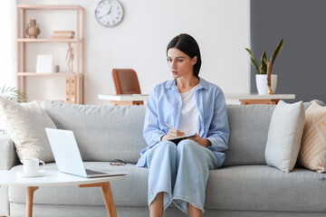 Female psychologist video chatting with patient on sofa at home