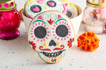 Bowl with skull shaped cookies and flower on grunge background, closeup. El Dia de Muertos