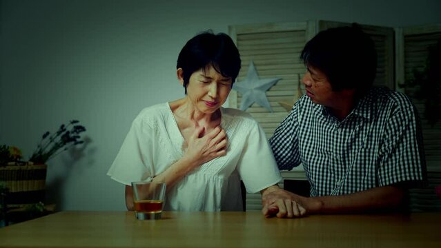 胸を押さえて苦しむ中年女性　医療イメージ