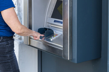 Ein Frau am Geldautomat tipt den Betrag ein 