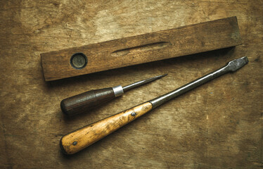 Vintage wooden builder's tool on an old table. Screwdriver, awl, wooden water level.