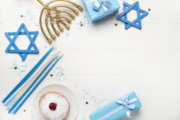 Frame made of plate with tasty doughnut, gifts and decor for Hanukkah celebration on white wooden...
