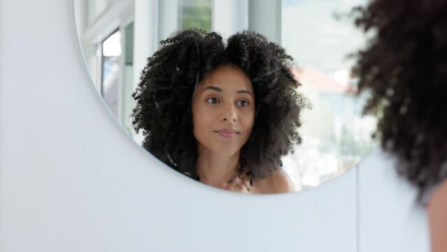 Hair care, beauty and woman with an afro in bathroom getting ready for the day at her home. Self care, wellness and girl from Puerto Rico with beautiful, healthy and natural hair with curly hairstyle