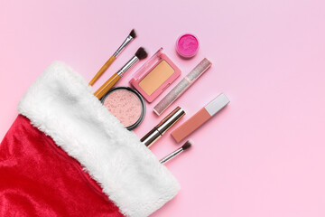 Christmas sock with makeup products on pink background