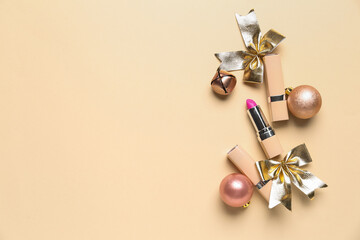 Lipsticks with Christmas balls, bell and bows on beige background