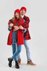 Obraz premium Loving couple in warm clothes hugging on grey background