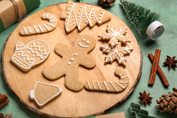 Wooden board with tasty Christmas cookies on color background, closeup