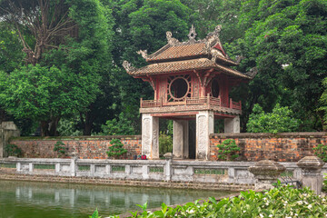 Colorful traditional tower pagoda structure and pond at the gardens of the Temple Of Literature in Hanoi Vietnam