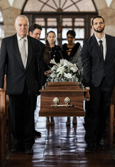 Funeral, church and family carry coffin for death, grief or sermon for burial with support. People, pallbearers and sad together with casket for respect, farewell or sorrow in mourning, mass or loss - obrazy, fototapety, plakaty