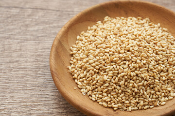 roasted sesame seed in wood plate on wooden table background. a pile of  Toast sesame seeds. roasted sesame                                                