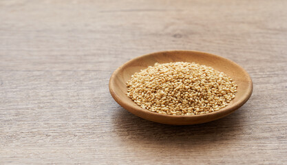 roasted sesame seed in wood plate on wooden table background. a pile of  Toast sesame seeds. roasted sesame                                                