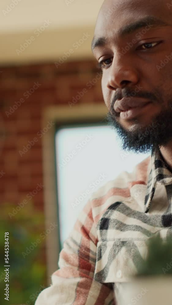 Poster vertical video: freelancer typing online information on laptop, doing remote work at home and using 