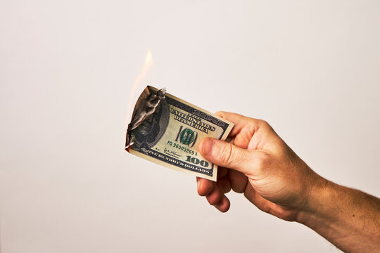 Male Hand Holding Burning Dollar Money On White Background