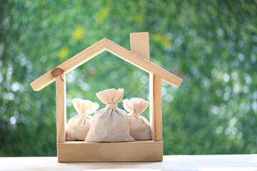 Mortgage,Model house and coins money in the bag on natural green background,Business investment and...
