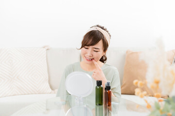 家で鏡を見ながら奥歯・親しらず・口内炎で悩む女性
