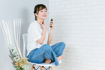 Fototapeta premium 椅子に座りながらネックケアするアジア人女性（首） 
